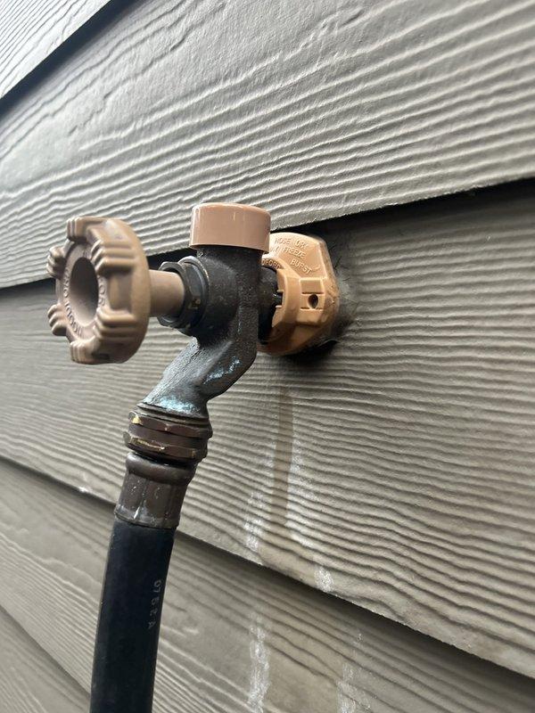 Responded to service call for leaking outdoor hose spigot. Upon inspection, identified failed valve assembly causing water seepage at the exterior wall-mounted faucet with backflow preventer. Accessed interior wall cavity through existing opening to evaluate supply line connections and assess extent of leak damage. Documented existing conditions of exterior spigot assembly, backflow prevention device, and interior plumbing penetration for repair recommendations.