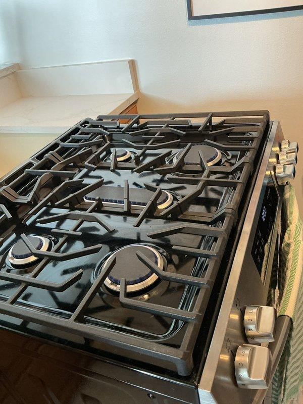 Responded to a gas cooktop service call at a 60-year-old condominium unit to uncap and adjust burners on a five-burner residential gas range. Removed transportation caps from burner assemblies, verified proper gas flow to all burners, and adjusted flame heights to manufacturer specifications. Tested ignition system and confirmed all burners were operating safely with proper blue flame patterns across varying heat settings.