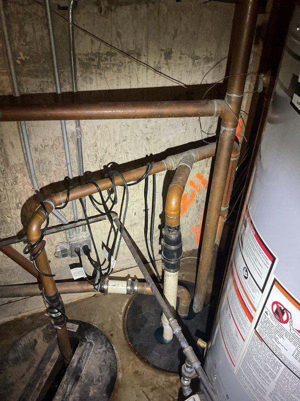 # Sump Pump Service Call

Responded to a non-operational sump pump in residential basement. Upon arrival, conducted diagnostic assessment of the 2-year-old sump pump unit that had ceased functioning. Performed thorough inspection of the pump assembly, float switch mechanism, discharge piping, and electrical connections to identify failure points.

Examined the basement utility area where the sump pump system is installed, noting the existing plumbing infrastructure including copper supply lines, water heater connections, and drainage systems. Documented current conditions of the mechanical room with photographic evidence showing the overall plumbing configuration, pipe routing, and equipment layout.

Assessed the sump pump's operational status by testing power supply, verifying circuit integrity, and examining the pump motor for signs of mechanical failure or electrical issues. Inspected the sump basin for debris accumulation, proper float operation, and adequate water level control fu