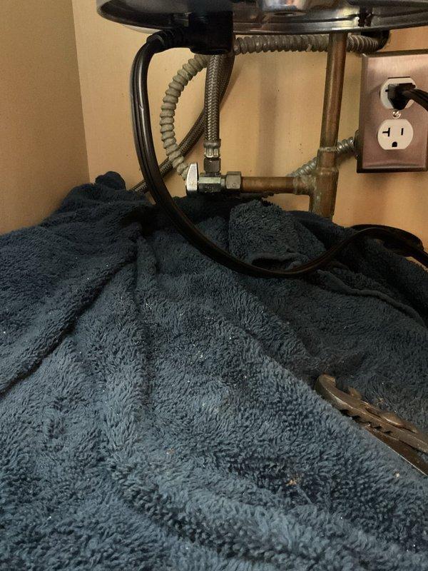 Responded to service call for leak under kitchen sink with suspected issue at dishwasher connection. Upon inspection, identified deteriorated braided supply line showing signs of oxidation and age-related wear. Replaced failed flexible supply line with new stainless steel braided hose and installed brass compression fittings to ensure proper seal at connection points. Tested all connections under pressure to verify leak was eliminated and system restored to proper working condition.
