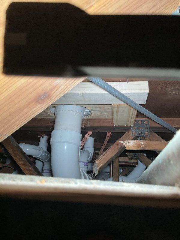 Responded to a service call for a toilet leaking at the base. Upon inspection, discovered a heavily corroded and deteriorated toilet flange with significant rust damage and water staining. Removed the existing toilet to access the damaged flange and assess the subfloor condition. The flange showed extensive corrosion around the mounting holes and inner ring, indicating prolonged moisture exposure. Inspected the underlying plumbing system, including PVC drain lines and structural support beneath the bathroom floor. Documented the condition of the corroded flange and plumbing infrastructure for repair recommendations.