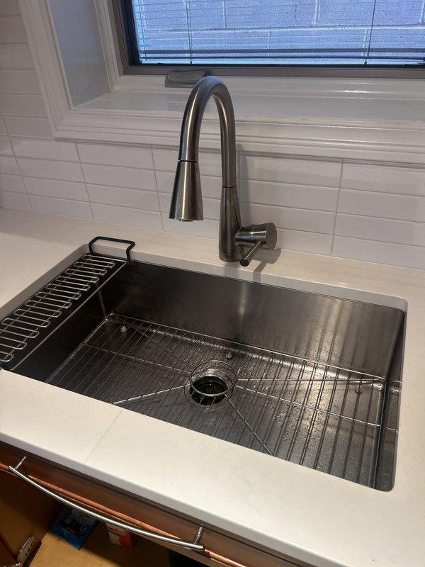 Responded to service call for multiple plumbing issues throughout the residence. Addressed leaking Kohler MasterShower body spray head, inspecting valve assembly and replacing worn internal components to eliminate water seepage. Serviced powder room sink faucet with dripping spout and loose handle—disassembled wall-mounted fixture, replaced deteriorated cartridge seals, tightened mounting hardware, and tested both hot and cold water controls for proper operation. Diagnosed reduced hot water flow at kitchen sink faucet while cold water pressure remained normal. Removed and cleaned aerator, finding mineral buildup and debris restricting flow. Inspected supply line connections beneath sink and confirmed no obstruction in hot water supply valve. All fixtures tested and verified operational with no leaks upon completion.