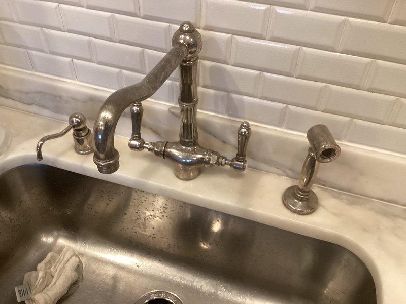 Responded to service call at 20-year-old residential property to address multiple plumbing concerns. Inspected and repaired non-functioning handle on upstairs master bathroom thermostatic shower valve with cross-handle controls. Evaluated guest bathroom shower head issue and performed necessary adjustments. Investigated knocking sounds in walls related to tankless water heater installation and identified source of water hammer. Documented existing shower fixtures including handheld shower system with slide bar and thermostatic mixing valve with dual cross-handle controls on white subway tile surround.