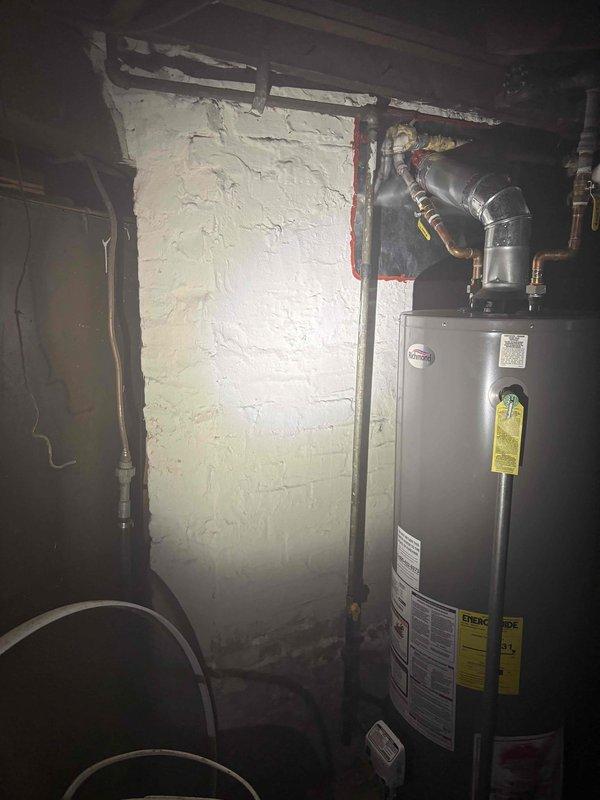 Responded to gas leak emergency call at residential property where gas service had been shut off as a safety precaution. Performed comprehensive inspection of basement utility area, focusing on gas piping connections to water heater and associated gas appliances. Conducted visual examination of copper gas lines, fittings, and connections throughout the mechanical room. Documented existing conditions with photographs showing water heater installation, overhead piping infrastructure, and basement utility configuration for service records and future reference.