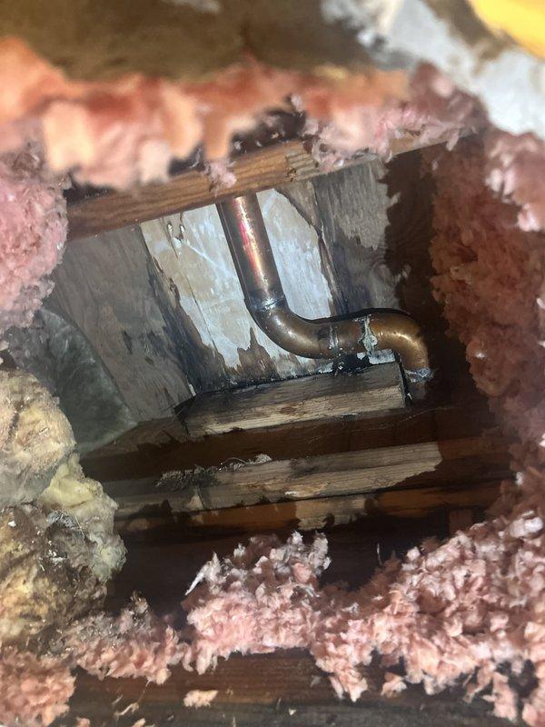 Responded to a third-floor shower with no water flow to the shower head and active water leak damaging the second-floor shower ceiling below. Performed investigative access through floor cavity to expose plumbing system between floors. Located copper supply piping and trap assembly within wooden joist structure, documented conditions with insulation removed to assess leak source and water delivery obstruction. Identified plumbing deficiencies requiring repair to restore proper water flow and eliminate ceiling leak.