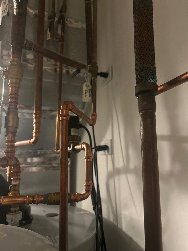 Responded to service call for reported broken water pump affecting residential property. Upon arrival, accessed property using provided lockbox and conducted thorough inspection of the plumbing system. Evaluated the booster pump assembly and associated copper piping network, including multiple ball valves, brass fittings, and distribution lines serving the domestic water system. Examined the pump installation mounted alongside water heater and related plumbing infrastructure. Documented existing conditions through photographs showing the complete piping configuration with various zones and circuits. Assessed all connections, valves, and fittings for proper operation and identified issues affecting water pressure delivery throughout the home. Maintained communication with homeowner throughout the service visit to provide updates and recommendations for resolving the water pump malfunction.
