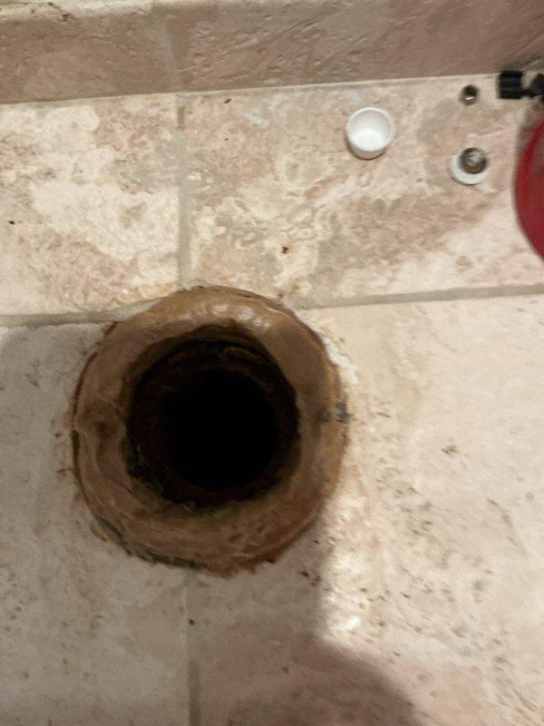 Responded to a residential plumbing service call addressing two issues: a leaking toilet caused by a pressure system malfunction within the tank, and a leaking garbage disposal unit. Upon inspection of the 25-year-old condo unit, assessed the toilet's internal pressure components and identified the source of water leakage. Examined the garbage disposal installation beneath the kitchen sink, including the mounting assembly, discharge connections, and P-trap configuration to locate the leak origin. Documented existing conditions of both fixtures, noting the age-related wear on the toilet bowl and the current plumbing setup of the disposal system with its chrome drain piping and plastic discharge components.