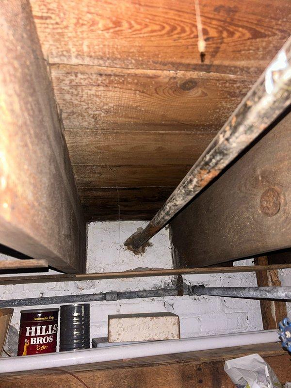 Completed plumbing estimate and inspection of existing piping system in attic crawl space. Documented aged galvanized steel pipes with visible surface corrosion, supported by wooden blocks and plastic mounting clips attached to structural framing. Photographed pipe routing, support conditions, and blue valve assembly for comprehensive assessment of system condition and replacement requirements.