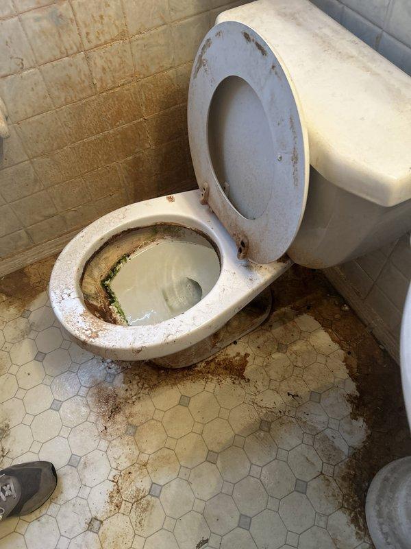 Responded to service call for continuously running toilet. Upon inspection, found deteriorated flapper valve and corroded internal tank components causing constant water flow. Tank water showed significant discoloration indicating sediment buildup and potential supply line corrosion. Replaced faulty flapper valve and chain assembly to restore proper flush cycle and stop water waste. Inspected fill valve mechanism and adjusted water level to manufacturer specifications. Noted extensive rust staining on tank hardware and toilet mounting bolts, as well as significant deterioration of surrounding flooring and water damage to wall surfaces, which may require future attention. Tested flush mechanism multiple times to verify proper operation and confirm complete seal after each cycle. Toilet now functioning correctly with no continuous running.