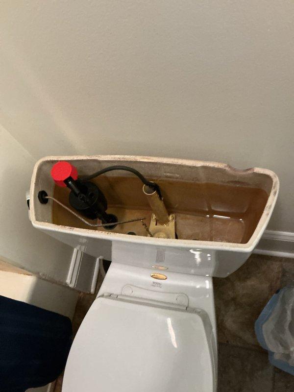 Responded to service call for toilet leaking at wall connection. Upon inspection, identified water seepage from the tank-to-bowl mounting area. Removed tank lid to assess internal components and check for additional issues contributing to the leak. Inspected fill valve, flapper assembly, and tank bolts for wear or deterioration. Determined leak originated from compromised tank-to-bowl gasket and loose mounting hardware. Tightened tank bolts to manufacturer specifications and verified proper seal. Tested flush mechanism multiple times to confirm leak was resolved and no water was escaping at connection points. System restored to proper working condition.