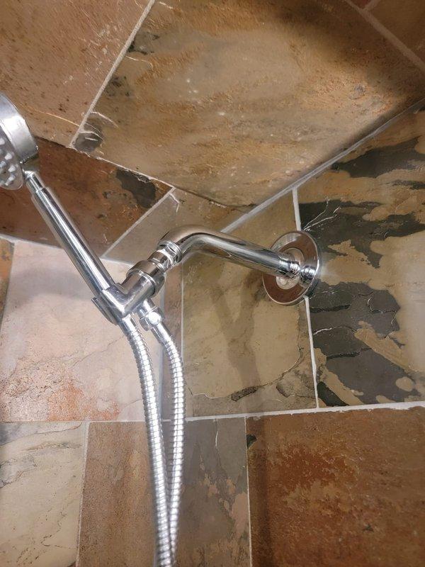 Conducted on-site estimate for complete shower and bathtub plumbing fixture replacement in a 20-year-old residential property. Upon inspection, documented extensive deterioration of existing shower enclosure including significant tile damage, dark mold and mildew growth, compromised grout lines, water staining, and mineral deposits throughout the beige ceramic tile surfaces. Evaluated chrome shower assembly with handheld fixture and flexible hose, tub/shower combination with glass enclosure, and existing mixing valve and spout configuration for replacement specifications.
