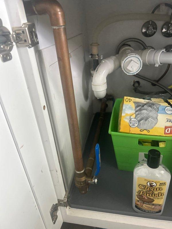 Conducted on-site assessment for whole-house water filtration system installation. Evaluated existing plumbing infrastructure including under-sink configuration with copper supply lines, PVC drainage system, and current shut-off valve locations. Documented cabinet space dimensions and plumbing access points to determine optimal placement for filtration equipment. Photographed existing water supply connections, valve assemblies, and available mounting locations to develop comprehensive installation plan for point-of-entry water treatment system.