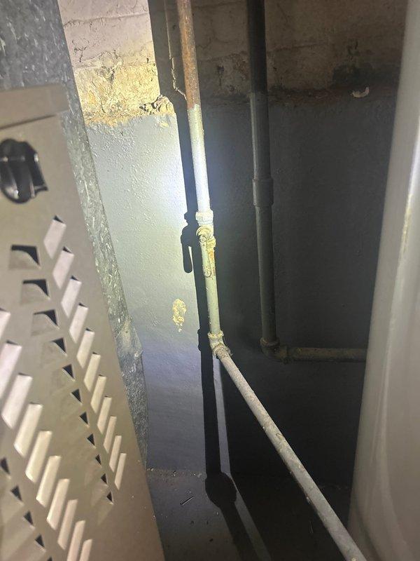 Replaced outdated gas valve for water heater by removing existing 3/4" valve from tee connection, plugging the line, and installing new 1/2" gas cock shut-off valve. Addressed flagged exhaust connection at chimney by removing concrete around exhaust pipe to expose connection point, disconnecting up to three pipework fittings, removing 4x4x3 fitting, and installing new exhaust wye with proper chimney pipe connection. Reconnected existing pipework and sealed around pipework with hydro cement to ensure proper seal and code compliance.