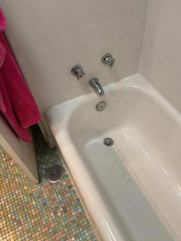 Responded to a clogged drain emergency at a 126-year-old residential condo where water was backing up through the trap and threatening to leak to the unit below. Upon arrival, assessed the bathroom plumbing system and identified the blockage affecting both the bathtub and sink drains. Successfully cleared the stoppage, restored proper drainage function, and verified water flow through the system. Advised the occupant that fixtures were safe to use and documented the completed work with photographs.