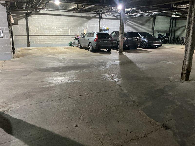 Responded to a drainage emergency at an underground parking garage where a broken pipe beneath the building was causing storm drains to back up during heavy rainfall. Conducted a thorough inspection of the affected area, documenting extensive water damage and moisture staining visible across the concrete floor surface. Photographed the compromised drainage system, exposed ceiling infrastructure including existing pipes and ductwork, and the overall condition of the parking structure to develop a comprehensive repair estimate for the subsurface pipe replacement and storm drain system restoration.