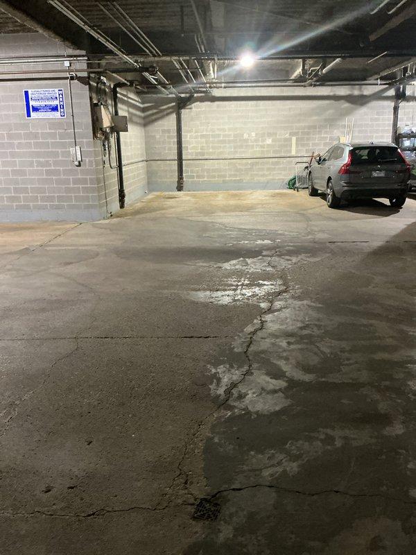 Responded to a drainage emergency at an underground parking garage where a broken pipe beneath the building was causing storm drains to back up during heavy rainfall. Conducted a thorough inspection of the affected area, documenting extensive water damage and moisture staining visible across the concrete floor surface. Photographed the compromised drainage system, exposed ceiling infrastructure including existing pipes and ductwork, and the overall condition of the parking structure to develop a comprehensive repair estimate for the subsurface pipe replacement and storm drain system restoration.