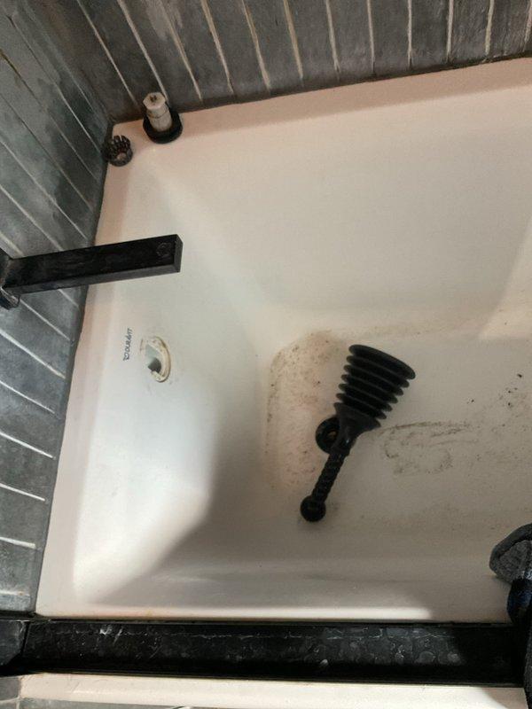 Responded to emergency service call for clogged shower drain in 1950s-era home. Upon arrival, found bathtub with significant drainage blockage preventing water flow. Deployed professional drain auger with flexible cable to access and clear the obstruction through the existing drain assembly. Successfully removed accumulated debris, hair, and soap buildup causing the blockage. Tested drainage flow to confirm full restoration of proper function. Left work area clean and operational.