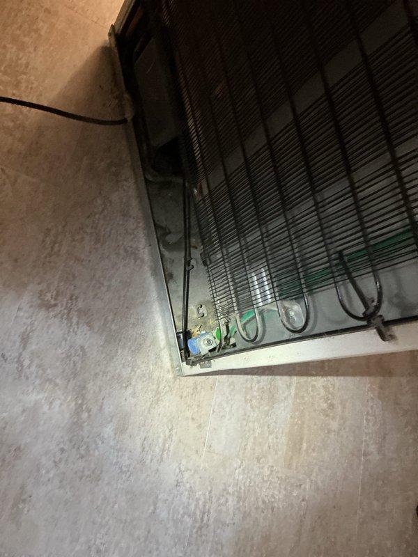 Responded to water leak complaint in 99-year-old residential property. Upon inspection, identified refrigerator supply line as primary source of leak affecting surrounding floor area. Accessed crawlspace and utility areas to assess extent of water damage to flooring and substructure. Inspected copper piping system throughout affected zone, checking for additional compromise due to age of plumbing infrastructure. Secured leaking refrigerator water supply line and verified all connections. Documented conditions of exposed piping, electrical systems, and structural components in utility spaces for homeowner records. Confirmed leak source isolated and water flow controlled.