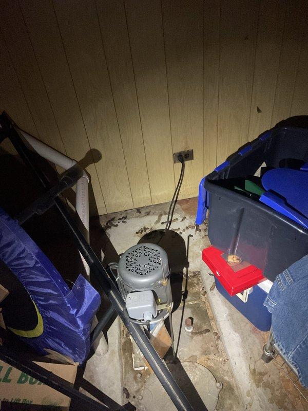 Responded to commercial property for basement water backup occurring during heavy rainfall and bathtub usage. Accessed confined utility space and crawl area to inspect drainage system and identify source of backup. Deployed drain cleaning equipment in deteriorated flooring conditions with visible debris accumulation, cleared obstruction from main sewer line, and documented pre- and post-service conditions of work area including PVC drainage piping and mechanical components.