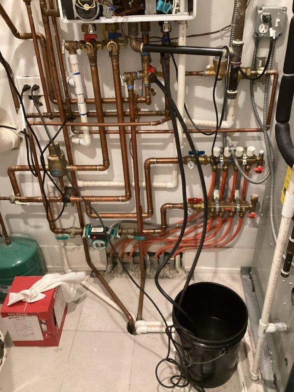Performed annual maintenance flush on Navien tankless water heater system. Isolated unit from hydronic distribution system using existing service valves, connected flushing equipment with descaling solution to inlet and outlet service ports, and circulated cleaning solution through heat exchanger for recommended duration to remove mineral deposits and scale buildup. Removed and inspected inline filter screen, which showed normal sediment accumulation. Reinstalled cleaned filter, thoroughly flushed system with fresh water to remove all descaling solution residue, restored unit to normal operation, and verified proper function with no leaks at connection points. System returned to service with optimal flow rates and heating performance.