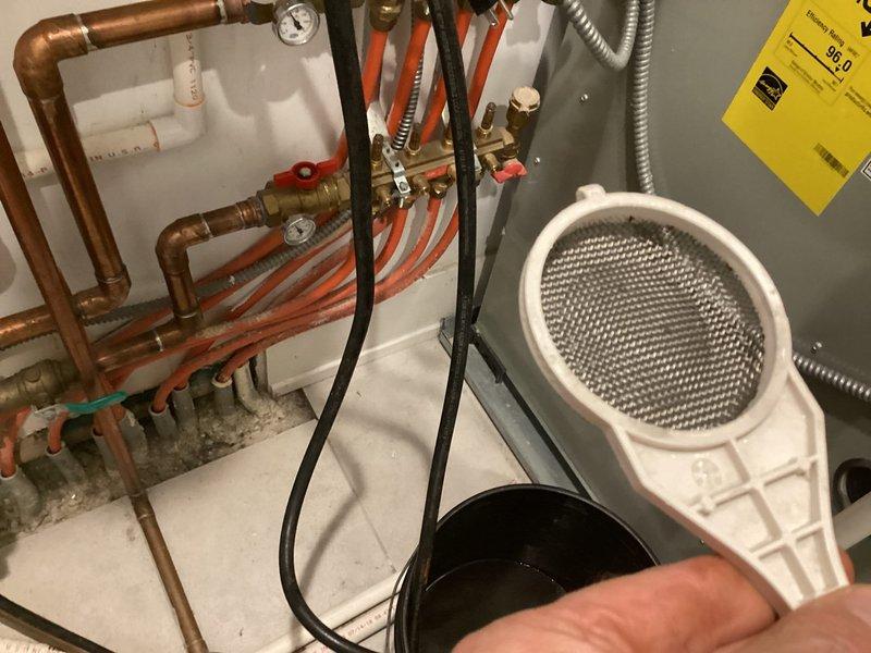 Performed annual maintenance flush on Navien tankless water heater system. Isolated unit from hydronic distribution system using existing service valves, connected flushing equipment with descaling solution to inlet and outlet service ports, and circulated cleaning solution through heat exchanger for recommended duration to remove mineral deposits and scale buildup. Removed and inspected inline filter screen, which showed normal sediment accumulation. Reinstalled cleaned filter, thoroughly flushed system with fresh water to remove all descaling solution residue, restored unit to normal operation, and verified proper function with no leaks at connection points. System returned to service with optimal flow rates and heating performance.
