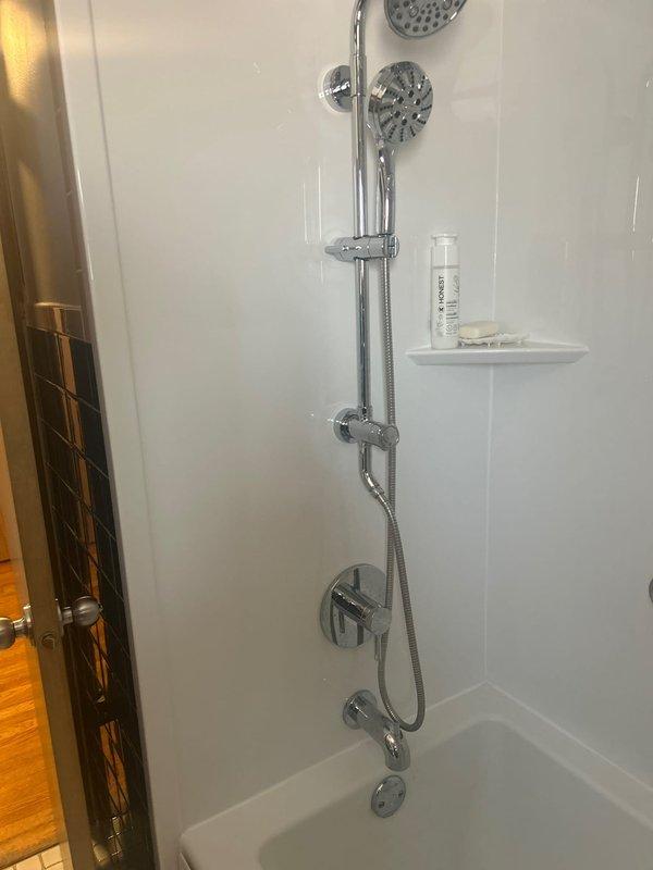 Responded to low water pressure complaint in 50-year-old residential property. Conducted comprehensive system evaluation including inspection of fixtures, supply lines, and pressure at multiple points throughout the home. Inspected bathroom shower system with dual rainfall and handheld showerhead configuration, tested flow rates and checked for potential blockages or restrictions in fixtures. Examined under-sink plumbing including P-trap assembly and garbage disposal connections for signs of corrosion, sediment buildup, or partial obstructions that could contribute to reduced pressure. Assessed age-related issues common in older plumbing systems including potential galvanized pipe deterioration and mineral accumulation in supply lines.