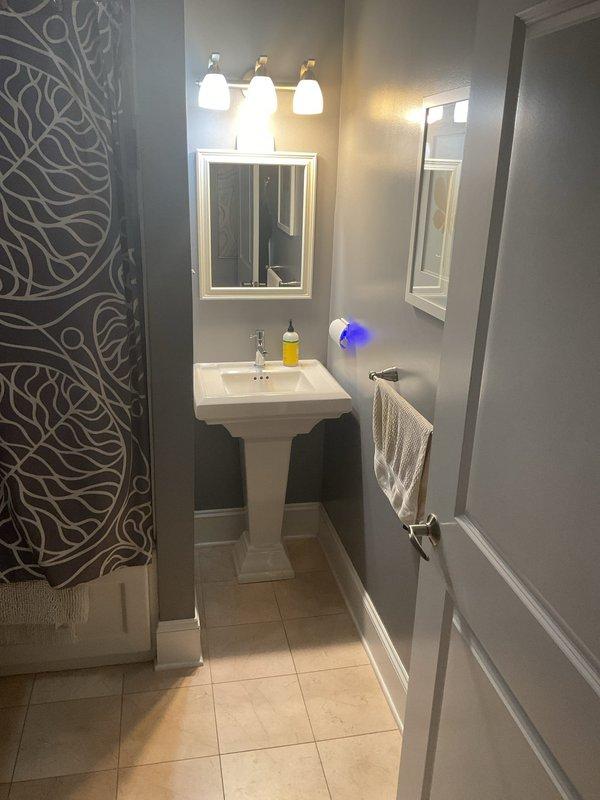 Responded to a slow-draining bathroom sink with backup issues. Accessed and cleared the clogged drain line located beneath stacked washer/dryer units in a closet alcove. Restored proper drainage flow to the pedestal sink fixture.