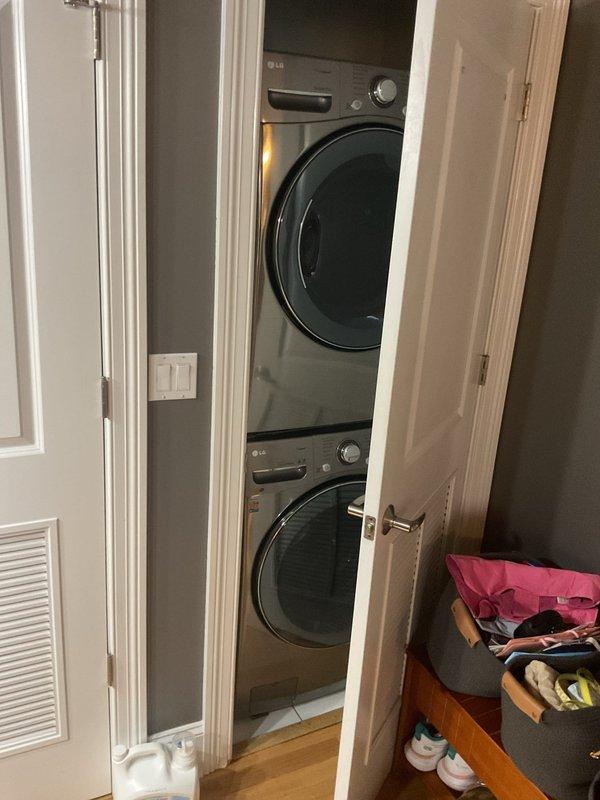 Responded to a slow-draining bathroom sink with backup issues. Accessed and cleared the clogged drain line located beneath stacked washer/dryer units in a closet alcove. Restored proper drainage flow to the pedestal sink fixture.