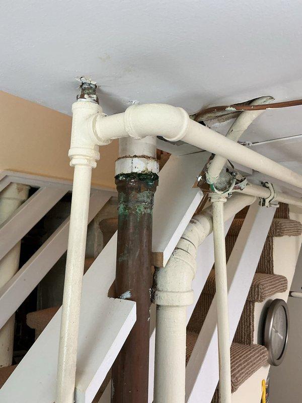 Responded to service call regarding low water pressure issue with APEC under-sink water filtration system. Upon inspection, identified severely corroded metal supply piping feeding the filtration unit, with visible green oxidation and deterioration at connection points to newer PVC sections. The corroded pipe was restricting water flow and causing significant pressure loss to the filter system. Documented existing plumbing conditions showing compromised metal piping requiring replacement to restore proper water pressure and prevent potential leaks or system failure.