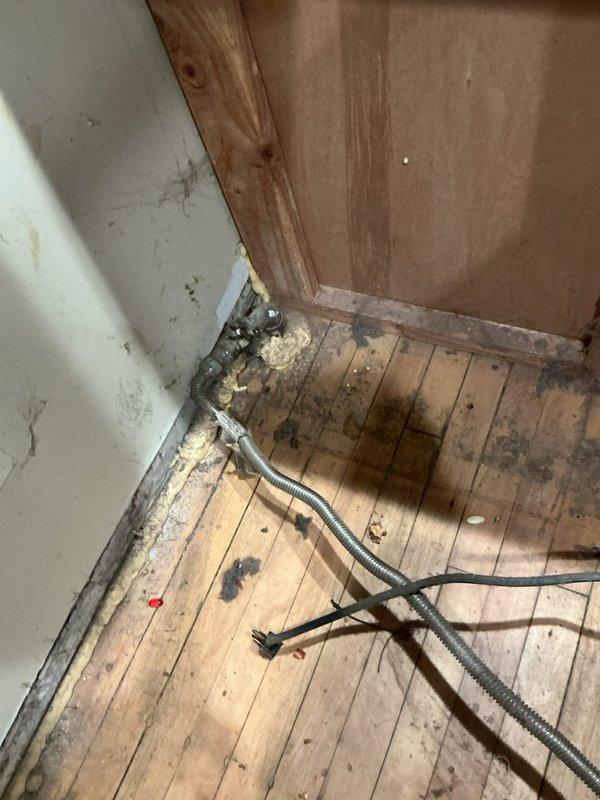 Responded to service call for reported gas leak at stove valve with appliances shut off. Performed visual inspection of gas system including meter, distribution piping, and appliance connections in basement utility area. Located leak at stove valve connection and documented existing conditions with photographs showing gas meter installation, copper supply lines, and affected valve area. Recommended repair or replacement of faulty valve to restore safe gas service to cooking appliance.