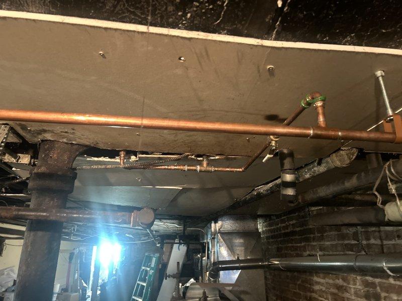 Replaced deteriorated 1/2" galvanized water supply line serving first floor bathroom fixture with new copper piping. Shut off water at isolation valve, drained cold side plumbing, and expanded existing drywall access opening to facilitate proper removal of corroded galvanized pipe and secure installation of copper line. Installed new 1/2" x 3/8" angle stop with braided stainless steel supply line and verified system functionality through pressure testing. All work includes one-year parts and pipework warranty.