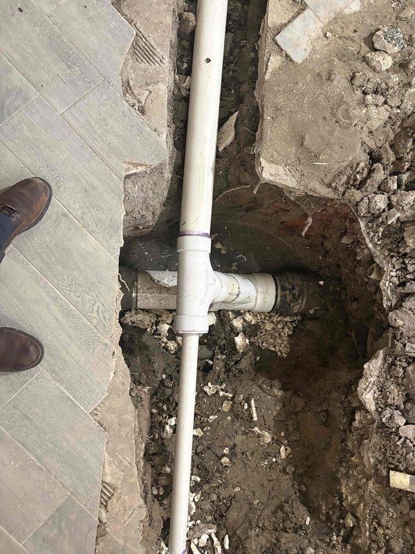 Completed estimate for residential ADU with improperly installed underground plumbing system. Previous plumber had excavated trenches correctly, but underground plumbing connections were not executed to code. Inspected interior construction area with exposed framing and spray foam insulation where white PVC drain lines run vertically and horizontally through excavated floor sections containing soil, rocks, and debris. Evaluated T-joint configurations and pipe routing emerging from and descending into trenched areas adjacent to existing concrete flooring. Documented current plumbing installation conditions to provide accurate estimate for correcting underground drainage system deficiencies and bringing work into compliance with applicable plumbing codes.