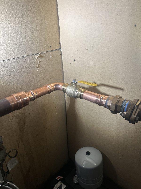 Completed building shutdown and plumbing repair work on water heater connections and associated piping. Replaced deteriorated flexible water supply lines, installed new brass fittings and shut-off valves with color-coded handles for easy identification, and re-soldered copper pipe joints to ensure leak-free connections. All work was completed with building systems secured and verified operational upon completion.