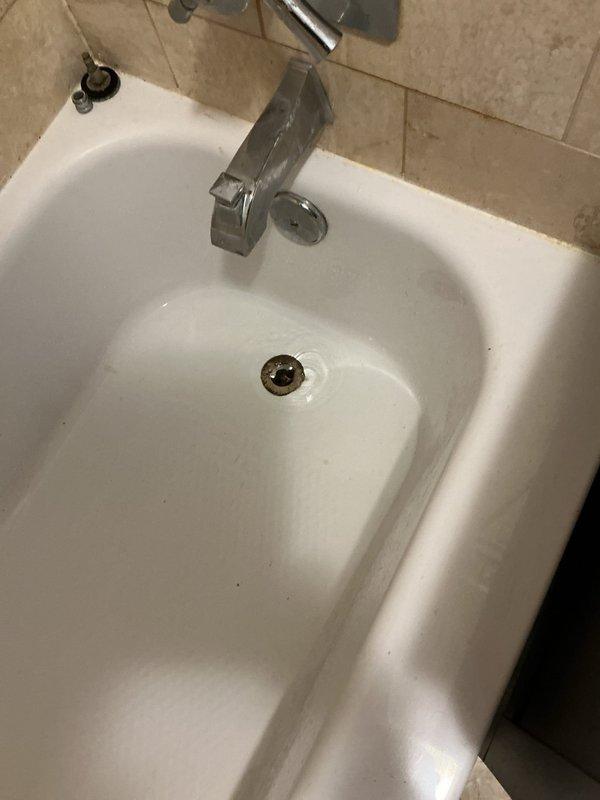 Responded to slow-draining shower in bathroom and assessed drain condition as requested. Upon inspection, identified hair and soap buildup causing partial blockage in the drain assembly. Cleared obstruction using appropriate drain cleaning tools and verified proper water flow. Examined the brass drain fitting and overflow assembly—both components found to be in serviceable condition with no signs of corrosion or structural damage requiring replacement. Tested drainage multiple times to confirm complete resolution and advised on preventive maintenance practices.
