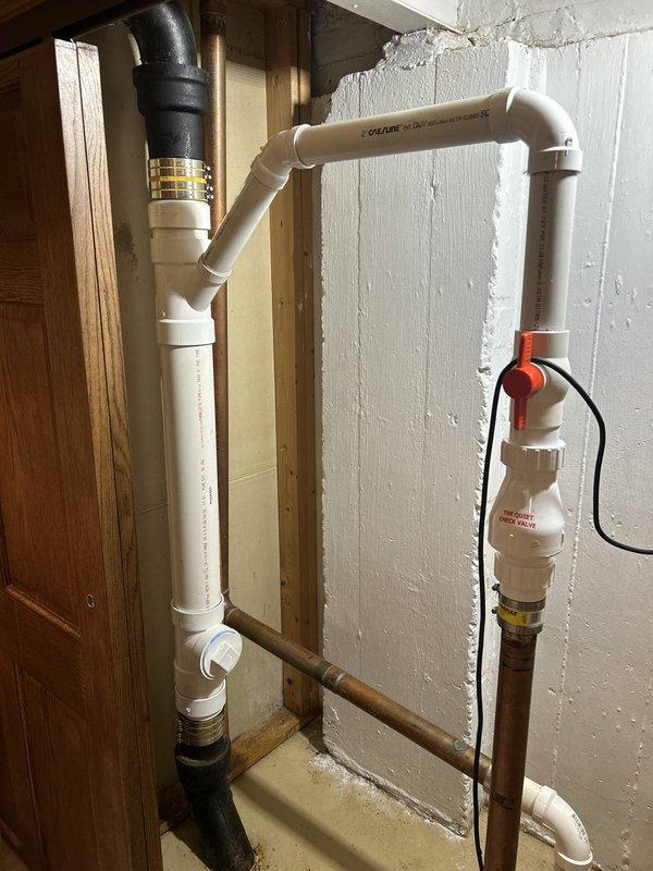 Completed plumbing estimate for sump pump area with deteriorated drainage and supply lines. Documented existing conditions including severely corroded cast iron vertical drain pipe with failing connections, oxidized copper supply lines with verdigris buildup at joints, and mixed PVC/copper configuration requiring assessment. The inspection revealed aging plumbing infrastructure with compromised pipe integrity, corroded fittings, and potential leak points at connection interfaces that will need replacement to ensure proper sump pump operation and prevent water damage.