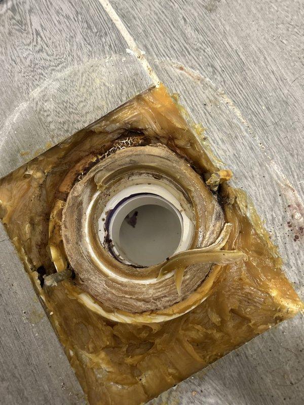 Responded to toilet leak investigation in century-old residential property. Upon inspection, identified improper sealing around toilet flange where PVC drain pipe penetrates subfloor. Previous foam sealant installation showed signs of deterioration and inadequate moisture barrier, contributing to leak conditions. Documented existing conditions including exposed multi-layer flooring around drain penetration and compromised foam insulation with visible staining indicating water intrusion. Assessed bathroom ceiling and ventilation system to determine extent of potential moisture damage from leak. Provided photographic documentation of flange area and overhead conditions for repair recommendations.