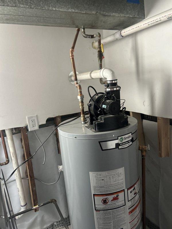 Successfully relocated a tanked water heater installation from its original position to the opposite wall within the utility area. The project involved disconnecting and repositioning an A.O. Smith tank water heater, including the recirculation pump system mounted on top of the unit. All supply and return plumbing connections were reconfigured, including copper water lines and PVC venting, with proper fittings and support brackets installed to meet code requirements. Electrical connections were relocated and secured, ensuring proper power supply to both the water heater and recirculation pump. The installation was completed with all components properly mounted, connections tested for leaks, and the system restored to full operational status.