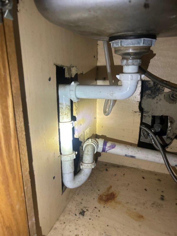 Conducted comprehensive plumbing assessment of century-old residential property to provide estimate for complete repiping of bathroom and additional areas. Evaluated existing lead and galvanized water supply lines throughout the structure, documenting deteriorated piping systems requiring replacement with copper piping to meet current code requirements. Inspected bathroom plumbing infrastructure including vertical pipe stacks experiencing active leak conditions. Assessed under-sink drainage system with PVC P-trap configuration and examined water heater installation with aged copper supply lines showing significant oxidation and patina. Documented existing plumbing conditions through photographic evidence including cabinet-mounted fixtures, supply line routing, and mechanical room infrastructure. Evaluated scope of work necessary to bring entire plumbing system into code compliance, focusing on bathroom stack replacement and transition from obsolete materials to modern copper distributi
