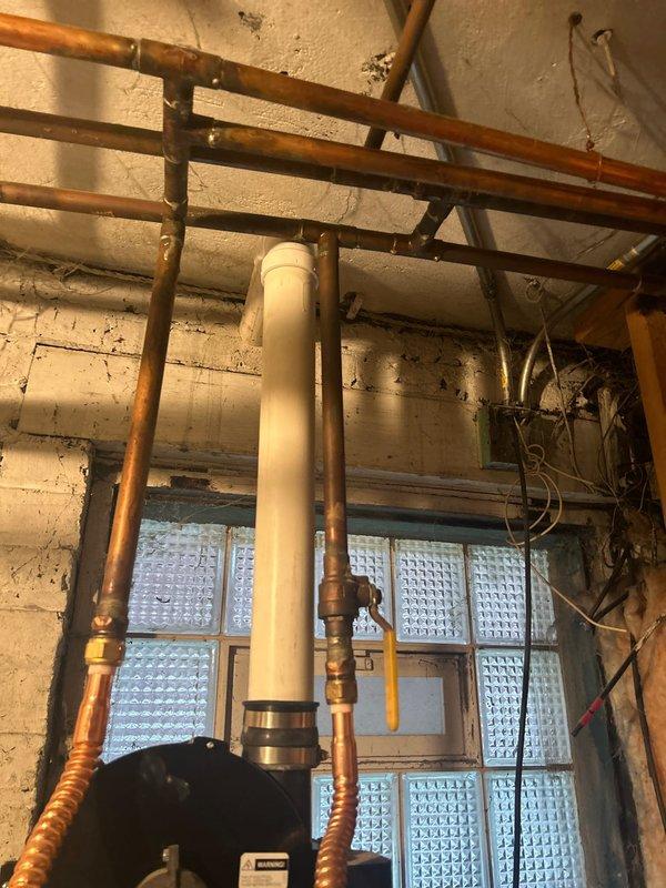 Conducted on-site assessment for water heater replacement in century-old residential property. Evaluated existing plumbing infrastructure including aged copper supply lines, distribution piping, and venting requirements for installation of 50-gallon power vent water heater unit. Documented current mechanical room conditions, existing pipe configurations with oxidized copper piping, PVC venting system, and available clearances for new equipment installation in basement utility area.