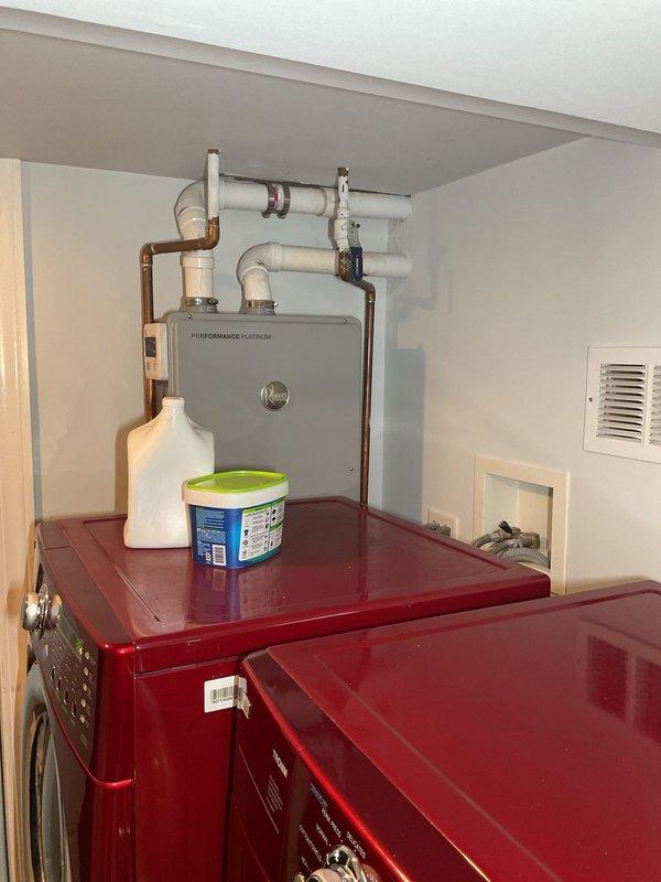 Performed camera inspection of residential plumbing system including water heater installation area and utility connections. Documented existing plumbing infrastructure including Rheem Performance Platinum tankless water heater, sump pump assembly, copper supply lines, PVC drainage system, and associated valves and fittings for diagnostic purposes.