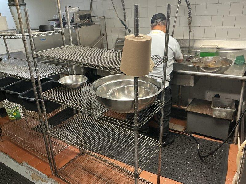 Responded to commercial kitchen drainage emergency where standing water and grease accumulation was present behind the dish machine area. Performed rodding service to clear the drain line and restore proper flow. Inspected cracked toilet fixture in restroom and provided estimate for replacement unit installation, and recommended VIP maintenance program to prevent recurring drainage issues at this restaurant facility.