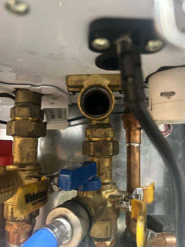 Responded to no hot water condition affecting entire home. Performed diagnostic inspection of tankless water heater system and identified maintenance issues requiring attention. Disassembled and inspected internal plumbing connections, including brass compression fittings, copper piping, and isolation valves. Removed and examined worn components including O-rings, gaskets, and threaded connectors that were contributing to system malfunction. Documented plumbing configuration and component condition through photographs. Completed system flush service to address sediment buildup and mineral deposits affecting unit performance in historic home. Reassembled unit with replacement seals and verified proper operation of all connections and valves.