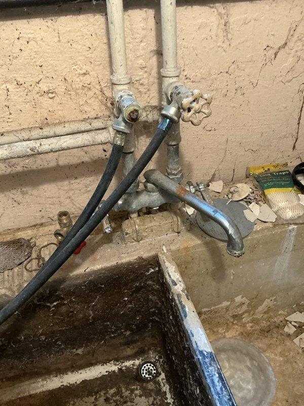 Responded to a leaky faucet issue in a basement utility sink. Upon inspection, found an aging plumbing system with corroded valve components and worn fittings consistent with the 60+ year age of the home. The constant dripping was caused by a deteriorated valve seat and compromised washers in the faucet assembly. Disassembled the faucet mechanism, replaced worn internal components including rubber washers and seals, and cleaned mineral deposits from the valve seat. Tested water flow and verified complete elimination of the drip. The utility sink's plumbing infrastructure showed significant age-related wear, corrosion on metallic fittings, and mineral buildup throughout the system. All connections were inspected for additional leaks, tightened as needed, and confirmed proper operation. The repair restored full functionality to the basement sink faucet with no residual leaking.