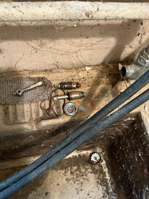 Responded to a leaky faucet issue in a basement utility sink. Upon inspection, found an aging plumbing system with corroded valve components and worn fittings consistent with the 60+ year age of the home. The constant dripping was caused by a deteriorated valve seat and compromised washers in the faucet assembly. Disassembled the faucet mechanism, replaced worn internal components including rubber washers and seals, and cleaned mineral deposits from the valve seat. Tested water flow and verified complete elimination of the drip. The utility sink's plumbing infrastructure showed significant age-related wear, corrosion on metallic fittings, and mineral buildup throughout the system. All connections were inspected for additional leaks, tightened as needed, and confirmed proper operation. The repair restored full functionality to the basement sink faucet with no residual leaking.