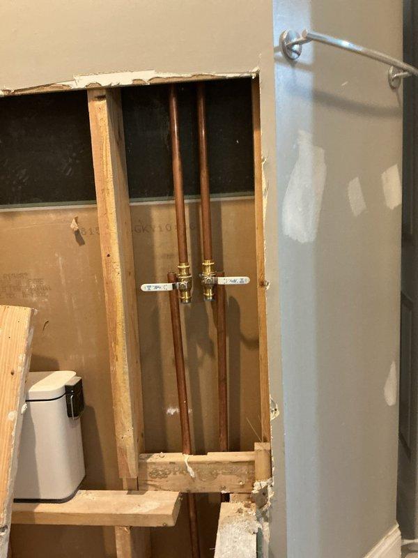 Conducted on-site assessment of bathroom renovation project to prepare plumbing fixture estimate. Documented exposed copper water supply lines, wall framing, and bathtub rough-in installation with valve assemblies in place, requiring coordination with project managers for comprehensive fixture pricing and scope determination.