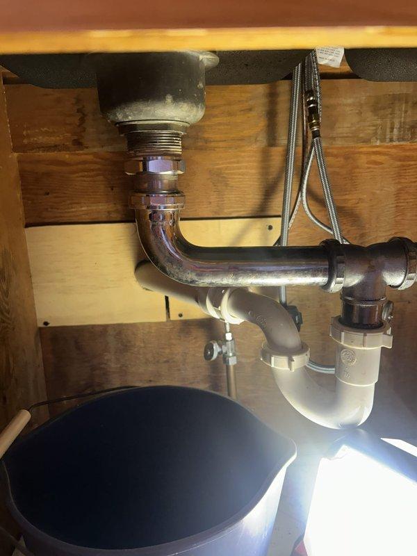 Responded to kitchen sink backup issue. Upon inspection, found deteriorated P-trap assembly requiring replacement. Removed existing chrome-plated P-trap and tailpiece assembly, installed new drain components, and tested system to confirm proper drainage and verify no leaks at connections.