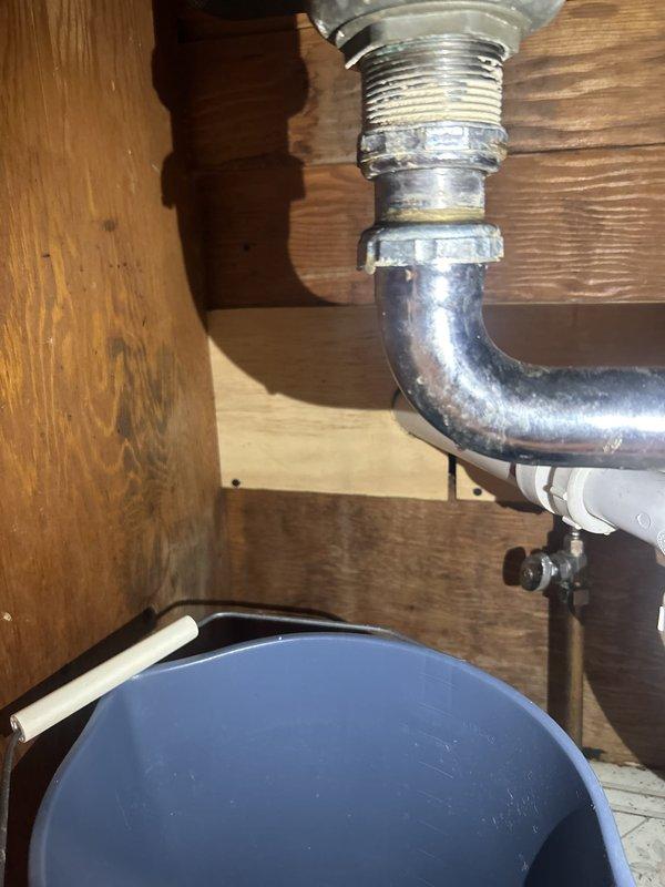 Responded to kitchen sink backup issue. Upon inspection, found deteriorated P-trap assembly requiring replacement. Removed existing chrome-plated P-trap and tailpiece assembly, installed new drain components, and tested system to confirm proper drainage and verify no leaks at connections.