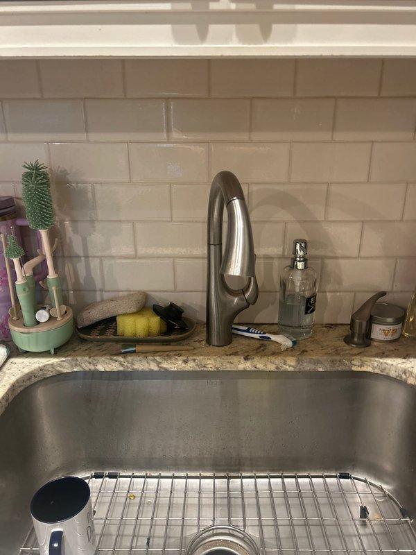 Coordinated with building engineer to shut off and drain water supply to the building. Replaced aging 1/2" IP x 3/8" compression angle stops serving the kitchen sink, including installation of a compression tee on the cold water angle stop to maintain water feed for the refrigerator. Removed existing kitchen faucet experiencing low water pressure and installed customer-supplied Delta single-hole faucet with proper connections. Upon building water system repressurization, tested all fixtures for proper functionality and verified adequate water flow and pressure. All connections sealed properly with no leaks detected at angle stops or faucet installation points.