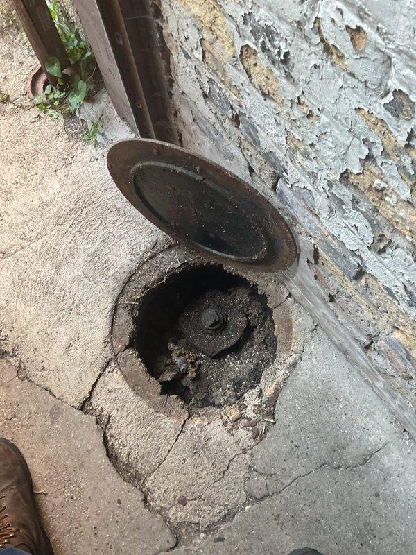 Conducted comprehensive plumbing and sewage inspection of condo building exterior drainage systems. Evaluated main sewer access point, downspout drainage connections, and foundation-level cleanout fixtures. Documented deteriorated conditions including corroded access covers, compromised concrete surrounding drainage points, and aging vertical downspout systems requiring monitoring for future maintenance needs.