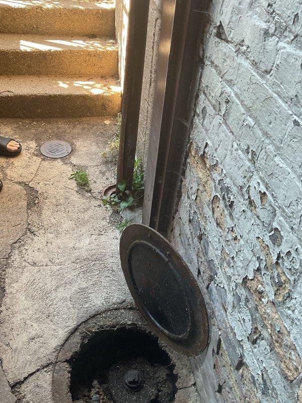 Conducted comprehensive plumbing and sewage inspection of condo building exterior drainage systems. Evaluated main sewer access point, downspout drainage connections, and foundation-level cleanout fixtures. Documented deteriorated conditions including corroded access covers, compromised concrete surrounding drainage points, and aging vertical downspout systems requiring monitoring for future maintenance needs.